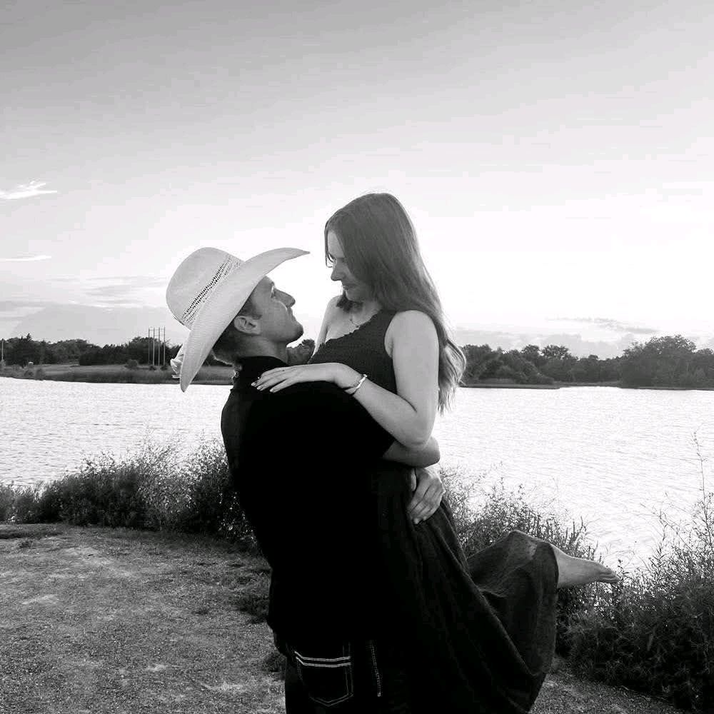 Black-and-white portrait of a couple embracing beside an Oklahoma lake